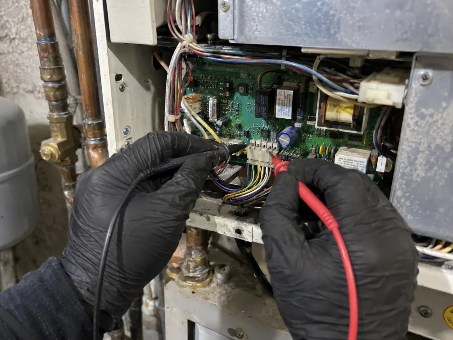 Close-up of internal boiler controls being inspected during a residential repair