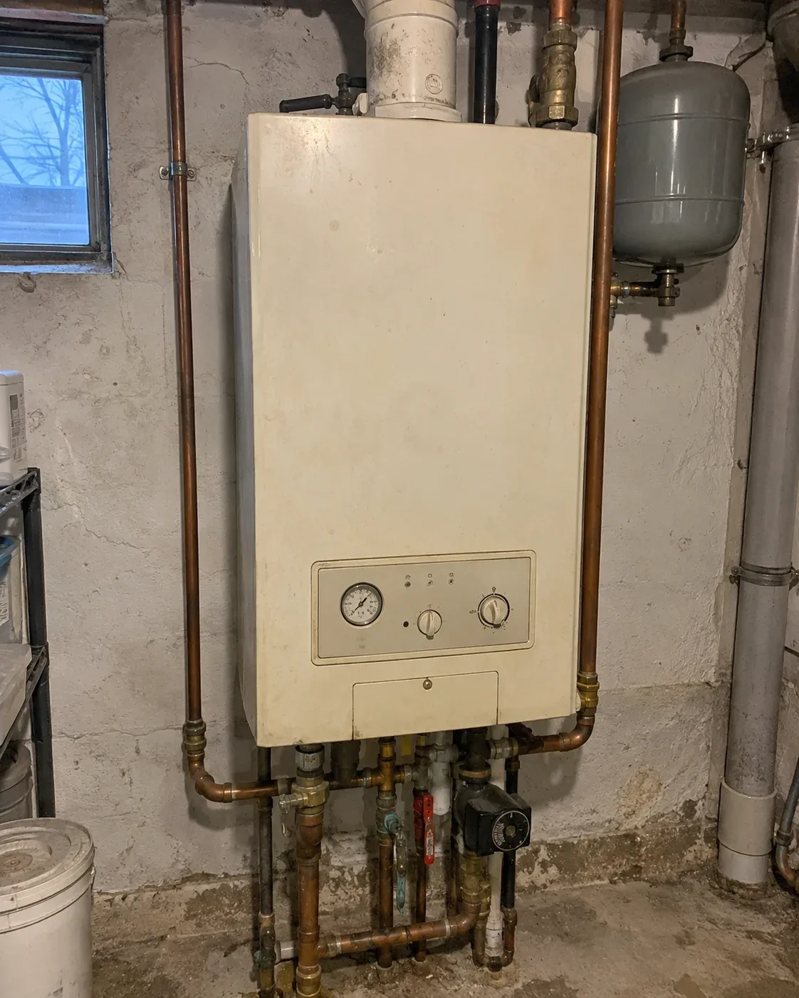 Older wall-mounted residential boiler before replacement in a Toronto home
