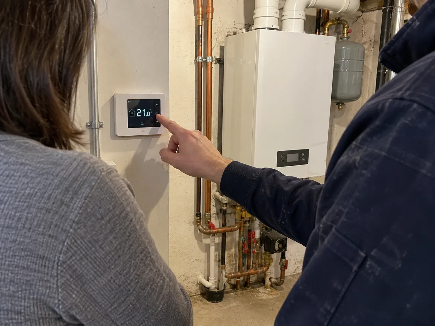 Boiler technician explaining thermostat controls to a Toronto homeowner