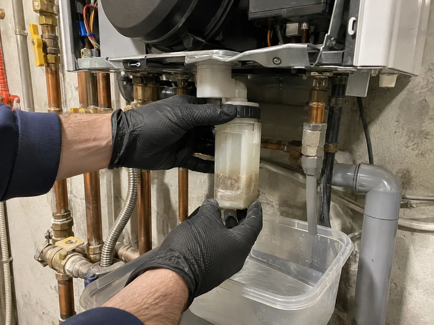 Technician cleaning a boiler heat exchanger during maintenance